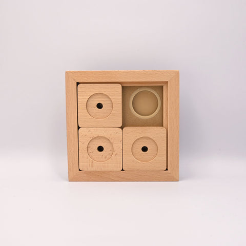 Wooden block puzzle with circular holes on a light gray background