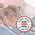 Dog lying on a rug with a 'Hand Made in Britain' logo in the foreground