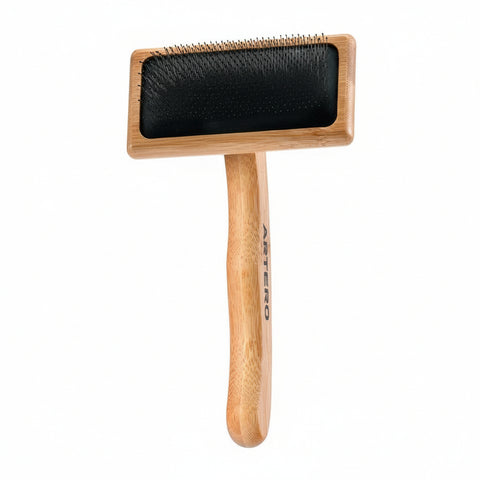 Dog grooming brush with wooden handle and black rubber block on a white background