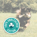 Dog running with a bone in its mouth on grass, with a '100% Unbleached Cotton' logo overlay.