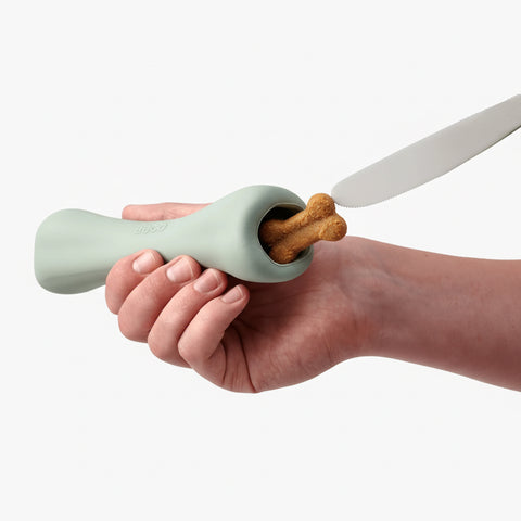 hand adding treats to beco rubber toy bone