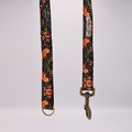 Floral patterned dog leash with brass hardware on a white background