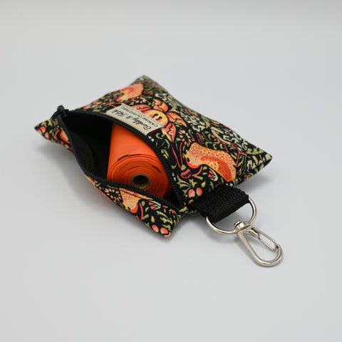 Patterned pouch with a keychain clip on a light neutral background.