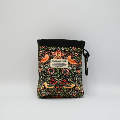 Floral-patterned pet treat pouch with a black base on a light neutral background.