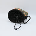 Floral-patterned pet treat pouch with a black base on a light neutral background.
