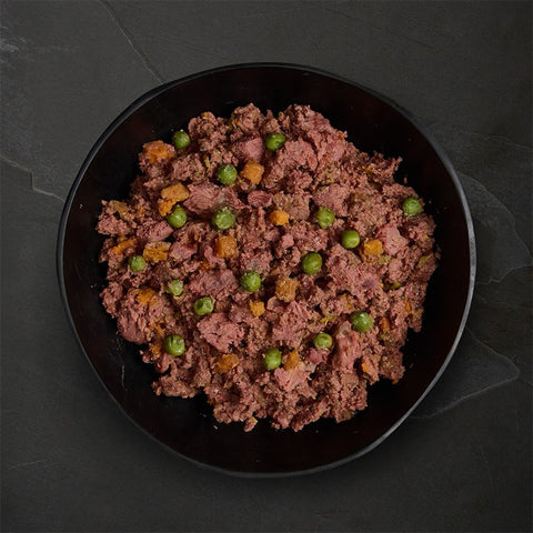 Black bowl filled with pet food mixture on a dark surface
