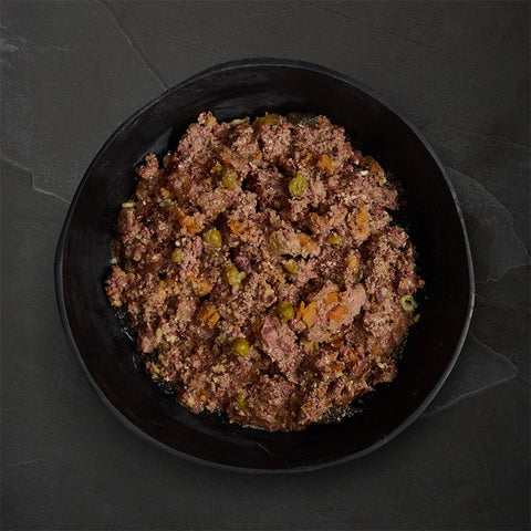 Black plate with ground meat mixture on a dark stone surface