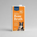A 500ml carton of Karnlea Chicken Bone Broth for dogs and cats, featuring an orange label with a blue brand logo and images of a dog and a cat.
