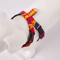 White dog model wearing a colorful Dakar harness on a light Grey background - Top view