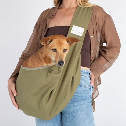 Hardwearing Dog Sling & Crossbody Bag, Fairtrade, Person holding a dog in an olive green sling against a white background
