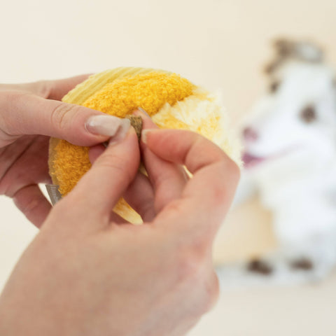 Person holding ading a treat to Toto, Enrichment Dog Toy, Silent, Snuffle Smaller Ball, Cornfield