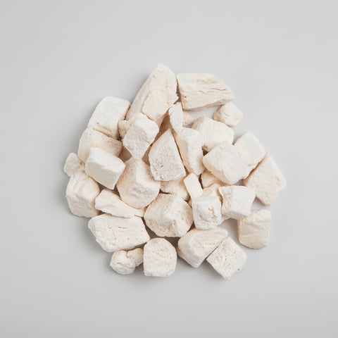 Diced chicken treats on a white background