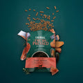 Tribal Fresh Pressed dog food package with scattered dog treats on a teal background