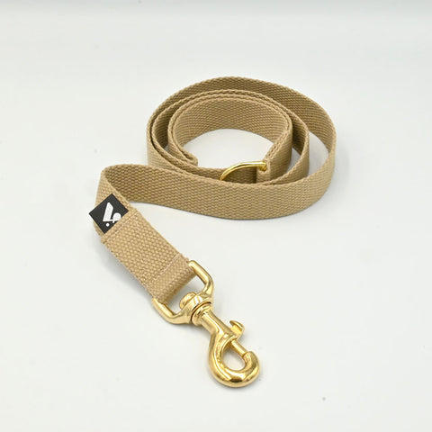 Beige dog lead with gold clasp on a white background