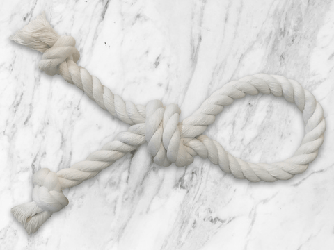 White rope tied in a knot on a marble surface