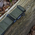 Green martingale collar with a buckle on a wooden surface with leaves in the background
