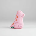 Pink dinosaur-shaped toy with orange spots on a white background