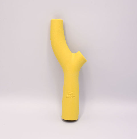 Beco's Yellow silicone stick-shaped toy on a light Grey background.