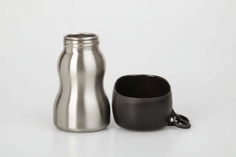 Stainless steel bottle and black mug on a white background