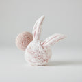 Pink bunny dog toy with a fluffy ball on a white background
