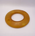 Round amber-colored Dog frisbee toy on a Grey background with visible branding.