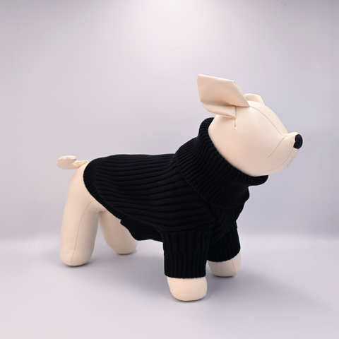 Stuffed animal wearing a black sweater on a light gray background