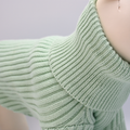 Close-up of a light green knitted sweater on a neutral background