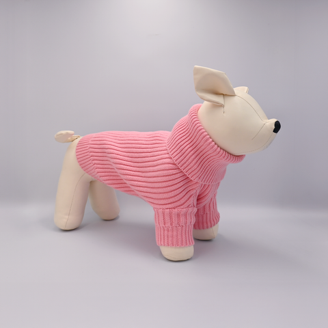 Stuffed dog toy wearing a pink sweater on a gray background