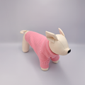 Dog toy wearing a pink sweater on a gray background
