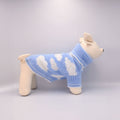 Dog wearing a blue and white patterned sweater on a light Grey background