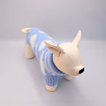 Dog manequin toy wearing a blue sweater on a grey background