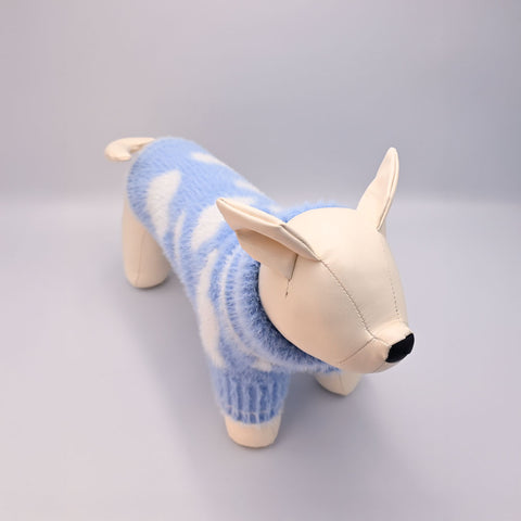 Dog manequin toy wearing a blue sweater on a grey background
