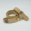 Beige dog lead and collar set with gold hardware on a light background